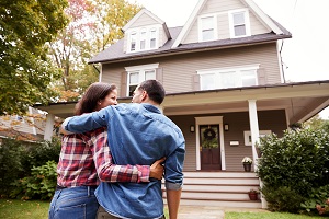 Couple standing outside looking towards their new house